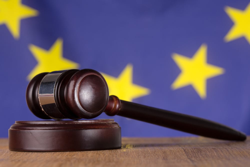 Gavel resting on sound block with european union flag in background-1