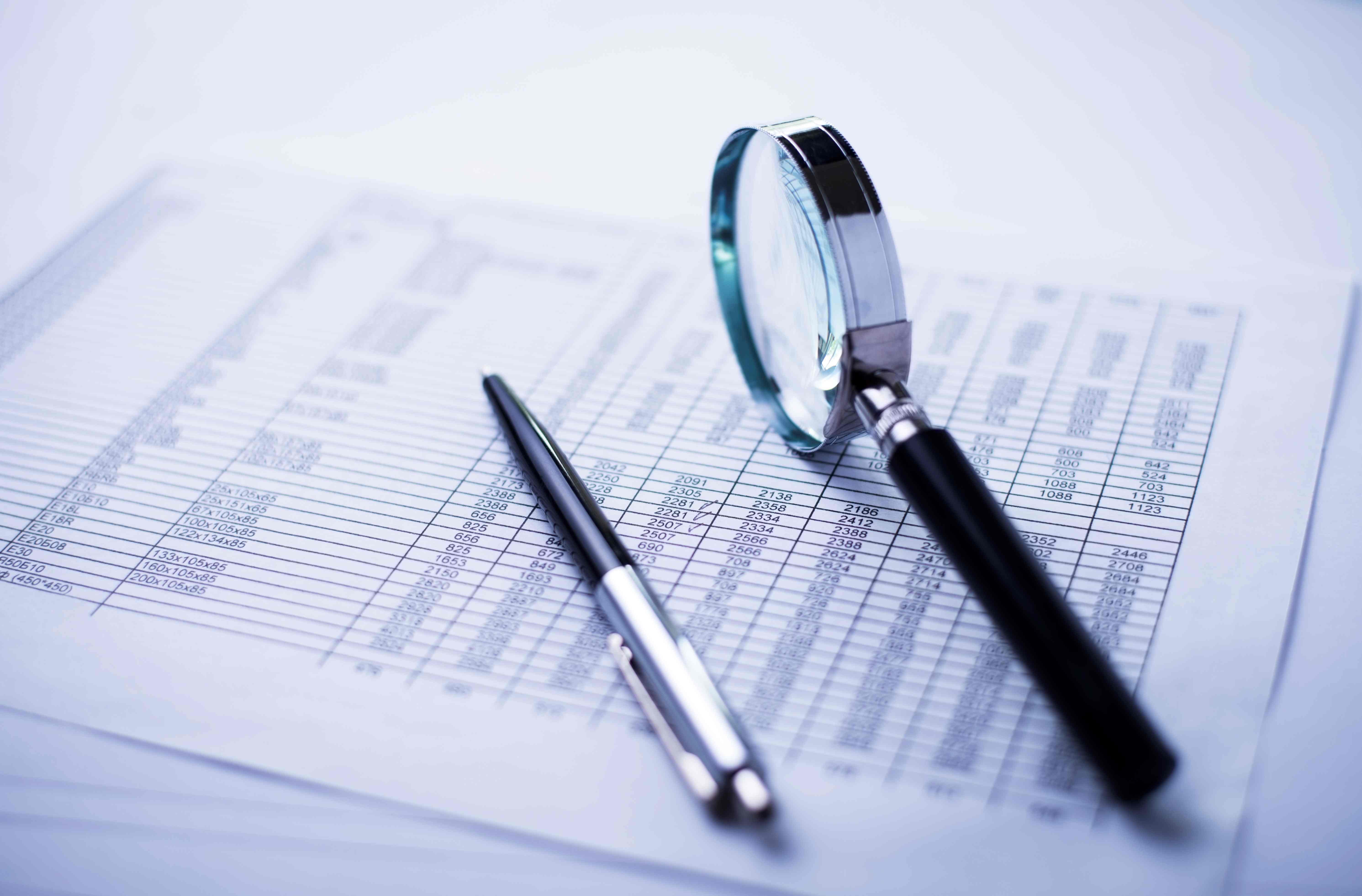 magnifying-glass-and-pen-on-financial-document-2026-01-07-06-35-33-utc